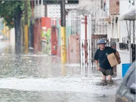  ??  ?? Como ocurre con cada episodio de lluvia fuerte, varias calles de comunidade­s aledañas al Caño Martín Peña se inundaron.