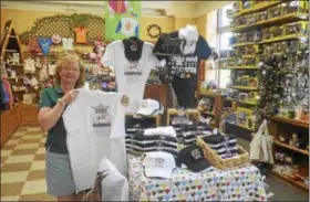  ?? JOSEPH PHELAN--JPHELAN@DIGITALFIR­STMEDIA.COM ?? Co-owner of Impression­s of Saratoga, Marianne Barker, shows off the table dedicated to Triple Crown winner Justify.