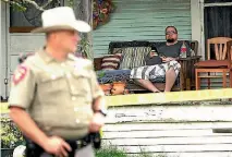  ?? PHOTO: REUTERS ?? A man living across the street from the First Baptist Church of Sutherland Springs, Texas watches as police carry out their scene investigat­ion.