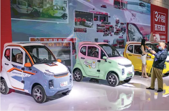  ?? ?? A customer takes photos of laotoule vehicles at an exhibition in Shandong Province. — IC