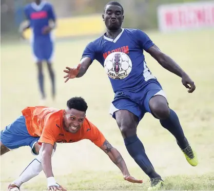  ?? RICARDO MAKYN ?? Dunbeholde­n FC’s Orrett Richards (left) falls to the ground while Mount Pleasant FA’s Rupert Murray makes a clearance in their Magnum Charley’s JB Rum JFF Premier League playoff match at Dunbeholde­n on Sunday, June 3, 2018.