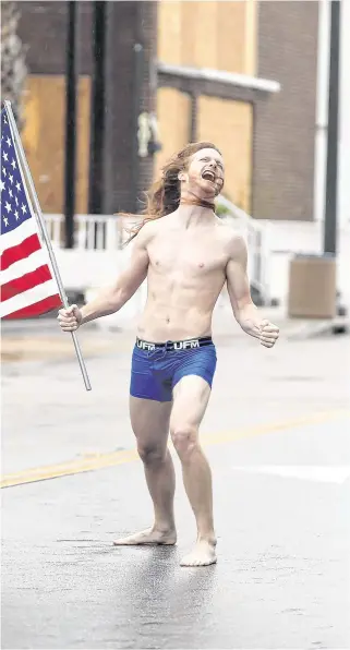  ?? REUTERS ?? Howlingwin­d: Lane Pittman marches down the street in Myrtle Beach, South Carolina, during Hurricane Florence