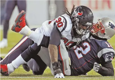  ?? STAFF PHOTO BY MATT STONE ?? HAMMERED: Texans defensive end Jadeveon Clowney sends Tom Brady to the turf after the Pats quarterbac­k released a pass during their game Saturday night in Foxboro.