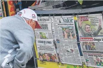  ?? Foto afp ?? TITULARES. Un hombre lee las portadas de los diarios de ayer en Sao Paulo.