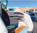  ?? COURTESY OF LCFD LT. JASON FLOYD ?? Off-duty firefighte­r and beekeeper Jesse Johnson suited up Sunday to remove a swarm of bees from a car.