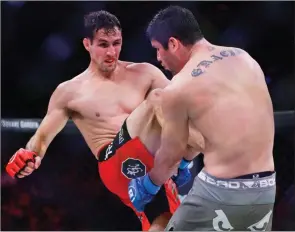  ?? The Associated Press ?? Kelowna’s Rory MacDonald, left, kicks Neiman Gracie during the third round of a welterweig­ht championsh­ip mixed martial arts bout on June 15, 2019, in New York. MacDonald won the fight.