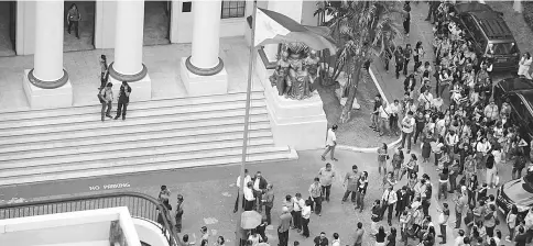  ??  ?? Court employees gather in front of their building after an earthquake hit Manila. — AFP photo