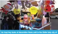  ??  ?? An Iraqi boy looks at decoration items sold in the Shiite holy city of Najaf.