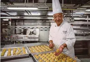  ?? AFP PIC ?? Chef Yip Wing-wah showing his freshly baked signature Spring Moon mini egg custard mooncakes at the Peninsula Hotel in Hong Kong recently.