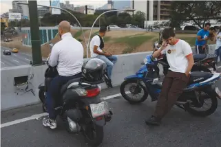  ?? REUTERS ?? MOTORISTS stop on a side of a highway trying to catch cellular service during a second day of blackout in Caracas, March 9.