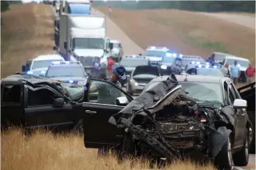  ?? Associated Press ?? ■ A Mississipp­i Highway Patrol state trooper investigat­es a wreck June 5 on U.S. Highway 45, south of Scooba in Kemper County, Miss. The crash that killed eight people in Mississipp­i in June happened after a box truck crossed the center line of a two-lane rural highway and struck a van, according to a federal report issued Wednesday.