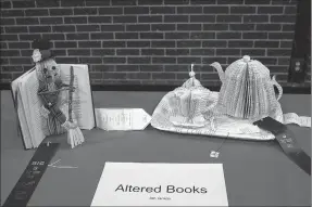  ?? MEGAN DAVIS/MCDONALD COUNTY PRESS ?? Above: Two McDonald County students, Ca’layn Gottfried and Kalyn Statina, received ribbons for their 3-D altered book art. Gottfried used the spine of the book as a backdrop, while Statina structured a tea set and resurfaced a tray with pages. Left:...