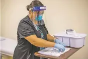  ?? JOHNS HOPKINS CENTER FOR AMERICAN INDIAN HEALTH VIA AP ?? Registered nurse Starla Garcia prepares a coronaviru­s vaccine in Chinle, Ariz., on Tuesday for someone who enrolled in the COVID-19 vaccine trials on the Navajo Nation and initially received a placebo.