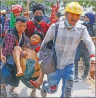  ??  ?? Anti-coup protesters carry an injured man March 14 following clashes with security forces in Yangon, Myanmar.
(File Photos/AP)