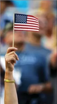  ?? WADE PAYNE — THE ASSOCIATED PRESS ?? A fan waves a small flag during the singing of the national anthem before the NASCAR Cup Series auto race, Saturday in Bristol, Tenn.