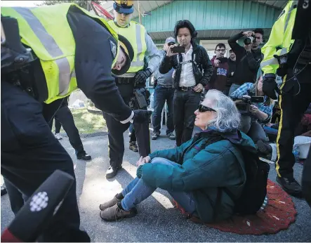  ?? THE CANADIAN PRESS/FILES ?? RCMP officers arrest a protester outside Kinder Morgan’s facility in Burnaby, B.C., in March. A total of 140 protesters made their first appearance­s on Wednesday in a Vancouver courtroom, with the first trial scheduled for May 7 for 10 protesters...