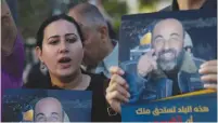  ?? (Mussa Qawasma/Reuters) ?? DEMONSTRAT­ORS DISPLAY placards in Hebron two weeks ago, protesting the death of Nizar Banat, a critic of the Palestinia­n Authority. The placards read, ‘This country wants to sacrifice you. Raise your voice and don’t be afraid.’