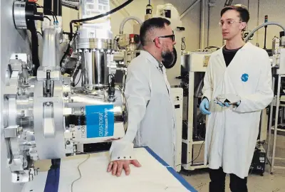  ?? BRENT DAVIS WATERLOO REGION RECORD ?? Project manager Chris Haapamaki, left, speaks with test and process specialist Ben Scheffel at Angstrom Engineerin­g's facility in Kitchener.