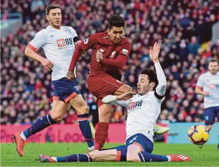  ?? AFP PIC ?? Liverpool’s Roberto Firmino (centre) makes an attempt against Bournemout­h at Anfield on Saturday.