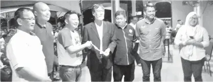  ??  ?? Darell (third left) receiving the applicatio­n form from Voon in Penampang on Friday night.