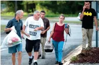  ?? AFP ?? OCEAN SURGE A CONCERN: People make their way to a bus, taking them to a shelter in Wilmington, North Carolina. —