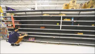  ?? Gerardo Mora / Getty Images ?? Walmart employee stocks Gatorade on an empty shelf on Wednesday in Orlando, Fla. Residents are preparing for Hurricane Dorian to hit as a possible category 4 storm over Labor Day weekend.