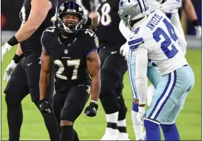  ?? (AP/Terrance Williams) ?? Baltimore Ravens running back J.K. Dobbins (left)) celebrates after running for a first down during the Ravens’ victory over the Dallas Cowboys on Tuesday night in Baltimore.