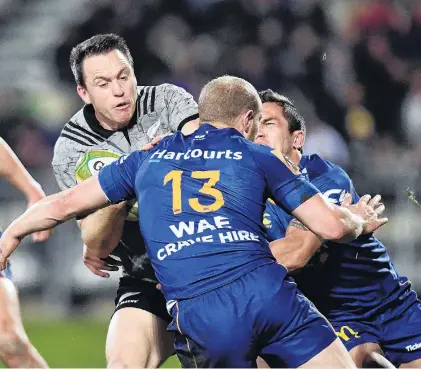  ?? PHOTO: GETTY IMAGES ?? Otago all . . . All Black fullback Ben Smith looks to burst through the tackle of Otago centre Matt Faddes as Matt Whaanga (obscured) assists at AMI Stadium last night.