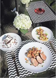  ?? RICK WOOD / MILWAUKEE JOURNAL SENTINEL Corie Knopick’s table is set with Southweste­rn pork tenderloin on potato hash, scallops with summer veggies and a ribbon cake for dessert. ??