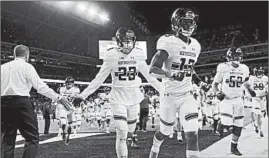  ?? NUCCIO DINUZZO/CHICAGO TRIBUNE PHOTOS ?? Northweste­rn certainly had its moments: Pat Fitzgerald, top, huddles with his players before the game; John Moten IV, middle, scores the Cats’ first TD; AD Jim Phillips, bottom, greets Northweste­rn players as they head into the locker room at halftime.