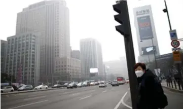  ??  ?? A woman is seen wearing a mask at a zebra crossing on a polluted day in Seoul, South Korea in this file photo. — Reuters photo