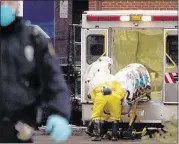  ?? SARAH HOFFMAN/ASSOCIATED PRESS ?? Health workers in protective suits unload Dr. Martin Salia, a surgeon working in Sierra Leone who had been diagnosed with Ebola, from an ambulance in Omaha, Neb.