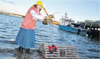  ?? KATHY JOHNSON PHOTOS ?? Lucy the Lob-STAR stretches her claws out as Donna Hatt helps her up on her weather predicting perch on the North East Point waterfront for her third Groundhog Day prediction.