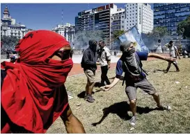  ?? VICTOR R. CAIVANO / ASSOCIATED PRESS ?? Protesters throw stones at police Monday outside Congress in Buenos Aires, Argentina, during a strike against a pension reform measure. Union leaders say the reform, which the lower house approved, will cut pension payments.