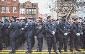  ?? JOHN MINCHILLO, AP ?? Police officers turn their backs as Mayor Bill de Blasio speaks during Sunday’s funeral of New York Police Department officer Wenjian Liu at Aievoli Funeral Home in Brooklyn. Liu and his partner, officer Rafael Ramos, were killed Dec. 20 as they sat in...