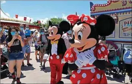  ?? PTI ?? The iconic cartoon characters Minnie and Mickey Mouse walk with the visitors at the Hong Kong Disneyland on Thursday