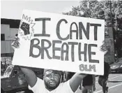  ?? STEPHEN MATUREN/GETTY ?? A man holds up a sign saying “I Can't Breathe” at a memorial for George Floyd on June 3 in Minneapoli­s, Minnesota.