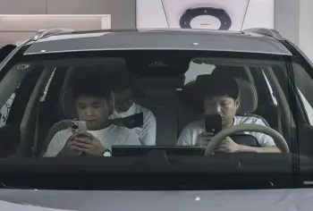  ?? GETTY IMAGES ?? Huawei customers in an electric car watching a a livestream of an event to launch new products, at a Huawei flagship store in Beijing. China’s President Xi Jinping wants a country that is already a leader in the production of mobile phones, chips, electronic devices and EVs to harness artificial intelligen­ce to press home its advantage.