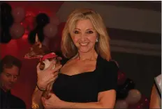  ?? Courtesy photo ?? Rescues on the Runway founder Mardi Rivetti holds a rescued pup during the “Head Over Heels for Rescues” fundraisin­g event. Festivitie­s included a holiday boutique and fashion show.