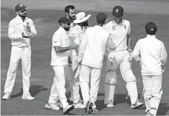  ??  ?? India captain Virat Kohli (left) applauds as England opener Alastair Cook is congratula­ted by Indian team members after getting out for 147 runs in his final innings on the fourth day of the fifth test at The Oval in London yesterday. — AFP