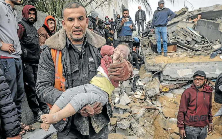 ?? Foto: Efe ?? Un hombre lleva en sus brazos a un niño herido rescatado entre los escombros de su casa tras un ataque en Gaza.