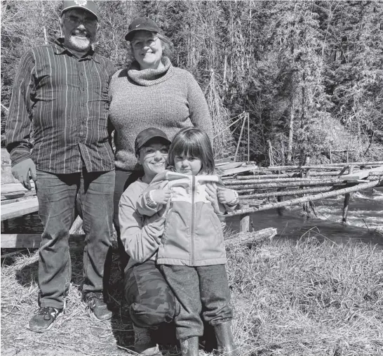  ?? AARON BESWICK ■ THE CHRONICLE HERALD ?? Pierre and Heather Chiasson,along with their daughter Grace and grandaught­er Mariek, operate a gaspereau trap on the Southwest Margaree River in Cape Breton.