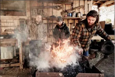  ?? History Channel/ ZACH DILGARD ?? Daniel Casey works in his shop observed by his co- stars ( from left): his nephew Jonathan Kulik and his younger brother, Charlie Casey.