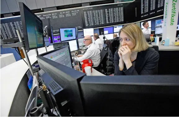  ??  ?? Traders monitoring financial data inside the Frankfurt Stock Exchange last week, as the equity rot continued to spread around global markets