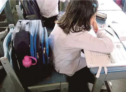  ??  ?? Beg sekolah yang diletakkan di atas kerusi memenuhi sebahagian tempat duduk pelajar.