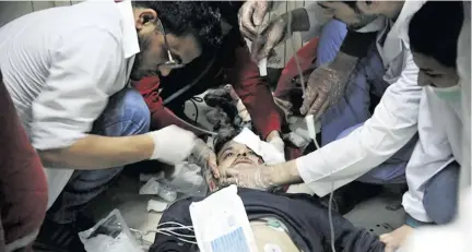  ??  ?? Medical personnel struggle to help one of the victims of the alleged chemical attack.