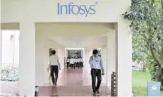  ?? — Reuters ?? Employees walk along a corridor in the Infosys campus in Bangalore.