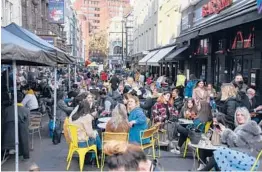  ?? ALBERTO PEZZALI/AP ?? Crowds of people gather at cafes and pubs Monday in London’s Soho district on the day some of England’s virus lockdown restrictio­ns were eased.