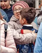  ?? ?? RELIEF: Woman hugs boy near school
