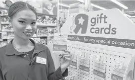  ?? Ben Margot / Associated Press ?? Toys R Us employee Davy Pen displays a Gift of College gift card in Emeryville, Calif. Gift of College helps people to contribute to college savings plans or pay down student loans.